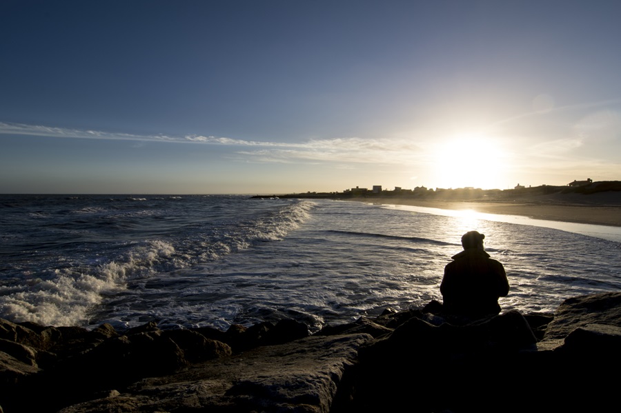 Silhouette of adult at a beach looking at sunset