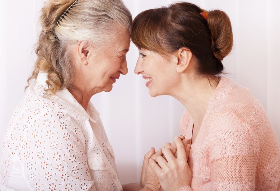 Senior woman smiling at her middle aged female caregiver