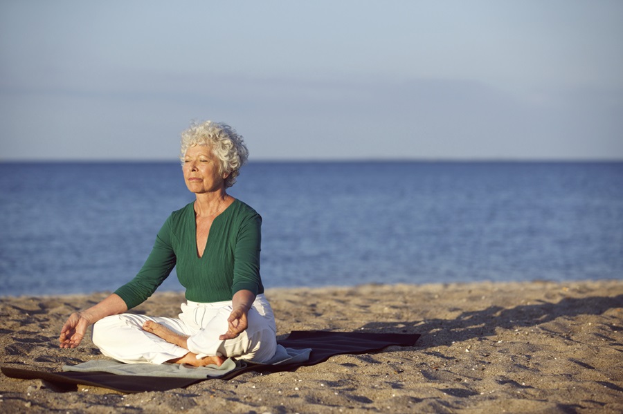 Woman with vitality doing yoga on the beach